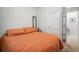 Comfortable bedroom featuring an orange quilted comforter, a small side table, and soft lighting at 11550 Lake Lucaya Dr, Riverview, FL 33579