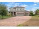 Charming two-story home with a three-car garage and a brick-paved driveway and stone details at 11550 Lake Lucaya Dr, Riverview, FL 33579