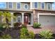 Charming two-story home showcasing stone accents, a brick pathway, and lush landscaping at 11550 Lake Lucaya Dr, Riverview, FL 33579