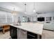 Open kitchen and living area with a large island and modern lighting fixtures at 11550 Lake Lucaya Dr, Riverview, FL 33579