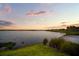 Picturesque lake view with lush green surroundings and a sandy beach area, perfect for outdoor relaxation at 11550 Lake Lucaya Dr, Riverview, FL 33579