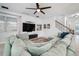 Cozy living area with a large sectional couch, ceiling fan, TV, and staircase, perfect for Gathering time at 11550 Lake Lucaya Dr, Riverview, FL 33579