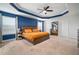 Comfortable primary bedroom with tray ceilings, large windows and dark wood furniture at 11550 Lake Lucaya Dr, Riverview, FL 33579
