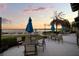 Waterfront patio featuring multiple tables with umbrellas, string lights, and lush landscaping at 11550 Lake Lucaya Dr, Riverview, FL 33579