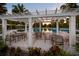 Poolside pergola with seating area and views of the resort-style pool and palm trees at 11550 Lake Lucaya Dr, Riverview, FL 33579