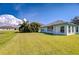 Well-maintained backyard with a scenic water view, lush green grass, and mature tropical landscaping at 11567 Weston Course Loop, Riverview, FL 33579