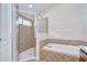 Bathroom features a soaking tub, glass enclosed shower and diamond pattern tile surround at 11567 Weston Course Loop, Riverview, FL 33579