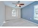 Bright bedroom with a ceiling fan, neutral carpet, and a lovely arched window offering plenty of natural light at 11567 Weston Course Loop, Riverview, FL 33579