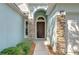 Close-up of the front entrance showcasing a brown door with stone pillars and manicured bushes at 11567 Weston Course Loop, Riverview, FL 33579