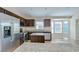 Well-appointed kitchen featuring granite counters, stainless appliances, dark wood cabinetry, and plenty of natural light at 11567 Weston Course Loop, Riverview, FL 33579