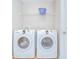 Functional laundry room featuring a washer, a dryer, and a convenient wire shelf for storage at 11567 Weston Course Loop, Riverview, FL 33579