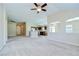 Open-concept living room with kitchen view featuring a ceiling fan and neutral walls at 11567 Weston Course Loop, Riverview, FL 33579