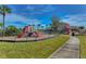 Fenced playground area with multiple play structures, slides, and green space in a Gathering-friendly community at 11567 Weston Course Loop, Riverview, FL 33579