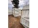 Open white wood gate in a backyard with sparse ground cover at 1233 Belleair Rd, Clearwater, FL 33756