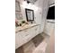 This bathroom features granite countertops, framed mirror and wood-look ceramic tile flooring at 1233 Belleair Rd, Clearwater, FL 33756