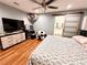 Stylish bedroom featuring laminate floors, a ceiling fan, and a sliding barn door to the en-suite bath at 1233 Belleair Rd, Clearwater, FL 33756