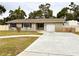 Charming single-story home featuring a well-maintained lawn and a paved driveway leading to an attached garage at 1233 Belleair Rd, Clearwater, FL 33756