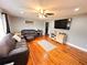 Cozy living room featuring hardwood floors, a ceiling fan, and a comfortable leather sofa set at 1233 Belleair Rd, Clearwater, FL 33756