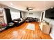 Cozy living room featuring hardwood floors, a ceiling fan, and a comfortable leather sofa set at 1233 Belleair Rd, Clearwater, FL 33756