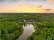 Overhead view of the community featuring serene lake views and lush tree coverage at sunset at 13409 Fawn Springs Dr, Tampa, FL 33626