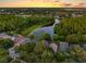 Stunning aerial view of a lakeside community at sunset, surrounded by lush greenery and picturesque homes at 13409 Fawn Springs Dr, Tampa, FL 33626
