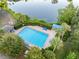 Aerial view of community pool surrounded by lush landscaping and lake views at 13409 Fawn Springs Dr, Tampa, FL 33626