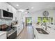 Modern kitchen featuring white cabinets, stainless steel appliances, and light wood flooring with water view at 13409 Fawn Springs Dr, Tampa, FL 33626