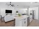 Open-concept living room featuring an island with quartz countertops, a ceiling fan and hardwood floors at 13409 Fawn Springs Dr, Tampa, FL 33626
