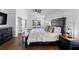 Inviting main bedroom featuring a large bed, hardwood floors, and a serene view of the outdoors at 13409 Fawn Springs Dr, Tampa, FL 33626