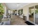 Spacious screened porch with an outdoor grill, and an open view to the kitchen and seating area at 13409 Fawn Springs Dr, Tampa, FL 33626