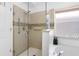 Modern shower featuring glass doors, mosaic tiles, and accessible grab bars for convenience and safety at 13409 Fawn Springs Dr, Tampa, FL 33626