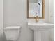 Modern powder room with a pedestal sink, and a gold-trimmed mirror at 1586 Running Tide Pl, Sarasota, FL 34240