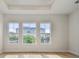 Sun-filled bedroom with beautiful hardwood floors and windows showcasing tropical views at 1586 Running Tide Pl, Sarasota, FL 34240