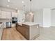 Bright kitchen featuring stainless steel appliances, island with sink and pendant lighting at 1586 Running Tide Pl, Sarasota, FL 34240