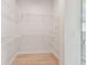 Bright walk-in closet featuring built in shelving and hardwood floors, offering convenient storage solutions at 1586 Running Tide Pl, Sarasota, FL 34240