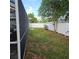 Fenced backyard with view of screen patio at 1663 Cambridge Dr, Clearwater, FL 33756