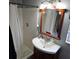 Bright bathroom featuring a white sink with a wooden vanity and shower with white tiled walls at 1663 Cambridge Dr, Clearwater, FL 33756