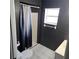This bathroom features a shower with curtain, a window, and black walls at 1663 Cambridge Dr, Clearwater, FL 33756