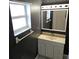 A classic bathroom featuring gray walls, white cabinets and tile floors, plus ample vanity lighting at 1663 Cambridge Dr, Clearwater, FL 33756