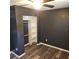 A bedroom with hardwood floors, a ceiling fan and a closet with white shelving offers plenty of storage at 1663 Cambridge Dr, Clearwater, FL 33756