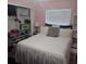 Pink bedroom with a white bed, open closet, and large window at 1663 Cambridge Dr, Clearwater, FL 33756