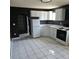 Well lit kitchen with stainless steel appliances, white cabinets, and gray walls and tile floor at 1663 Cambridge Dr, Clearwater, FL 33756