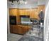 Well-lit kitchen with wooden cabinets, a countertop stovetop, and a double sink at 1663 Cambridge Dr, Clearwater, FL 33756