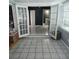 View of an expansive tiled sunroom featuring double doors and a window with blinds at 1663 Cambridge Dr, Clearwater, FL 33756