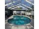 Backyard featuring a screened-in kidney-shaped pool and outdoor furniture at 1663 Cambridge Dr, Clearwater, FL 33756