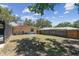 Large backyard featuring a sturdy fence, mature trees, and screened patio, perfect for outdoor activities at 1666 Pine Pl, Clearwater, FL 33755