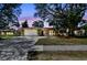 Charming single-story home with a well-manicured lawn, mature trees, and a two-car garage at 1666 Pine Pl, Clearwater, FL 33755