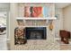 Close up view of the mosaic tile fireplace, with a rustic wood mantle and wood storage rack on the side at 1666 Pine Pl, Clearwater, FL 33755