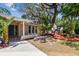 Inviting front entrance with lush landscaping, including palm trees and vibrant mulch beds at 1666 Pine Pl, Clearwater, FL 33755