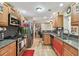 Charming kitchen with wood cabinets, granite countertops, stainless appliances, and checkered tile backsplash at 1666 Pine Pl, Clearwater, FL 33755